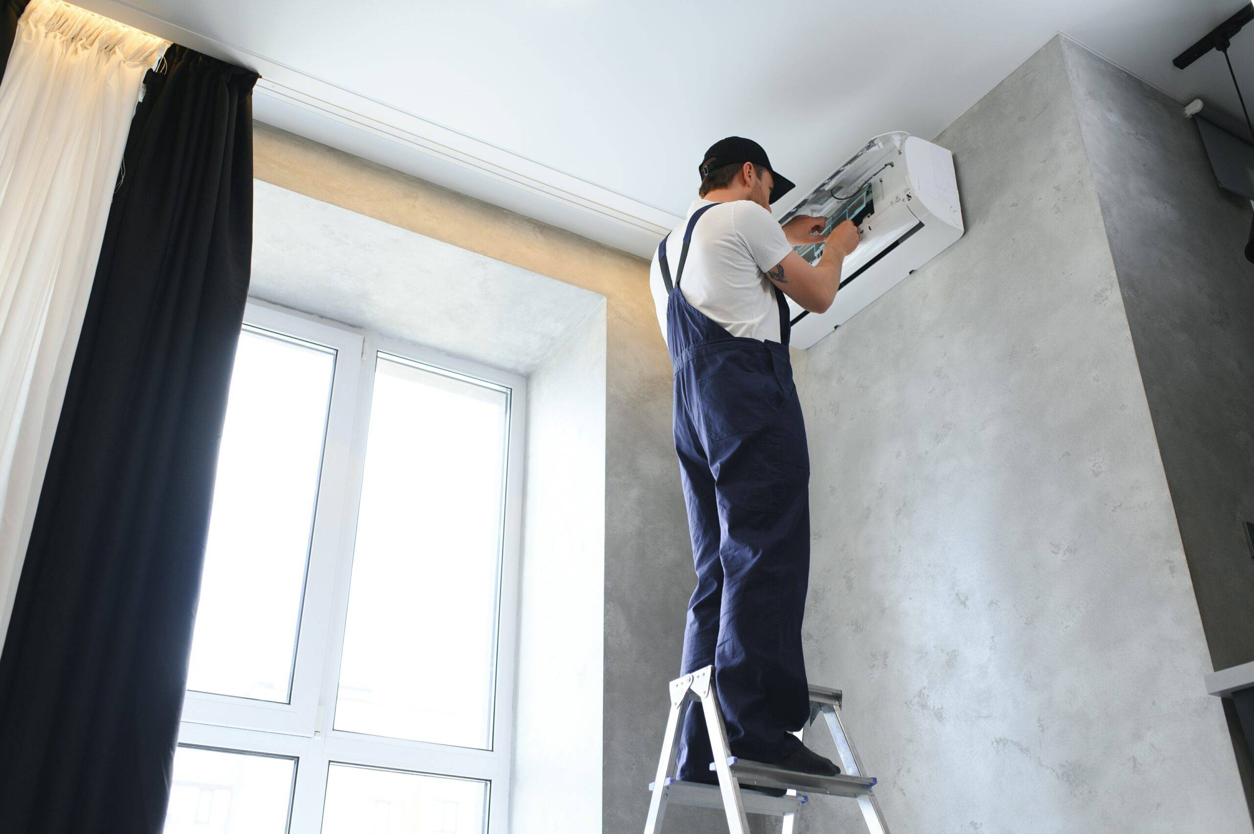 smiling-young-male-electrician-repair-conditioner